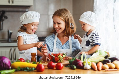 Healthy Eating. Happy Family Mother And Children  Prepares   Vegetable Salad In Kitchen