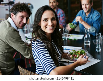 Healthy Eating Keeps Her Going Thorugh The Business Day. Portrait Of A Young Office Worker Eating Lunch With Coworkers At A Boardroom Table.