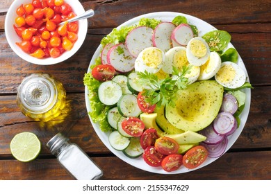 Healthy Eating Plate Of Avocado Salad With Eggs And Vegetables Over Rustic Wooden Table. Ketogenic And Paleolithic Diet. Top View