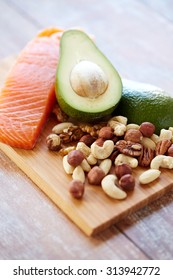 Healthy Eating, Protein Diet And Culinary Concept - Close Up Of Salmon Fillets, Avocado And Nuts On Table