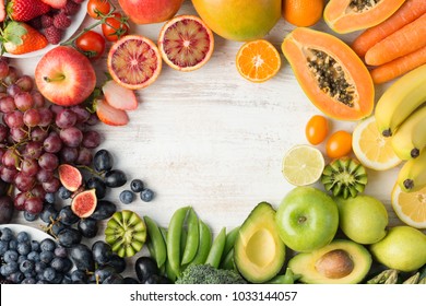 Healthy eating, varieity of fruits and vegetables in rainbow colours on the off white table arranged in a frame with copy space, vertical top view, selective focus