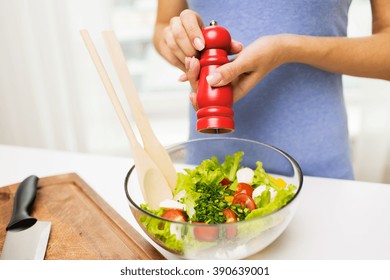 Healthy Eating, Vegetarian Food, Cooking And People Concept - Close Up Of Young Woman Seasoning Vegetable Salad With Salt Or Pepper At Home