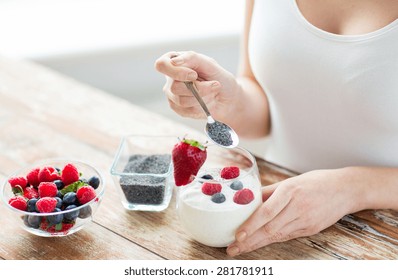 Healthy Eating, Vegetarian Food, Diet And People Concept - Close Up Of Woman Hands With Yogurt, Berries And Poppy Or Chia Seeds On Spoon