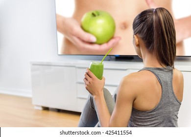 Healthy Eating Woman Drinking Green Smoothie Watching Television Online Education Tv Show About Nutrition And Weight Loss. Girl Sitting At Home Learning About Losing Weight With Vegetables And Fruits.