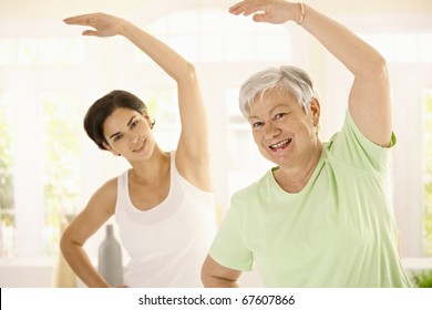 Healthy Elderly Woman Doing Exercises With Personal Trainer At Home, Smiling.?