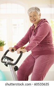 Healthy Elderly Woman Training At Home With Exercise Bike, Smiling.?