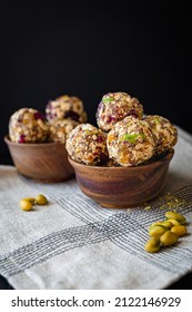 Healthy energy balls with dates, berries, flex and chia seeds, cranberries and pistachios in a wooden ball on a dark background 1