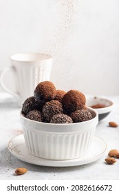 Healthy Energy Balls Sprinkled With Cocoa Powder. Vegan Chocolate Truffles In White Bowl. Vertical Image