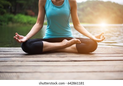 Healthy energy woman balance body and practicing yoga and meditate near water on the bridge in the nature.  Healthy Concept
