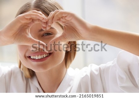 Healthy Eyes And Vision. Woman Holding Heart Shaped Hands Near Eyes. Girl Smiling and Showing Heart Symbol with Hands. Vision Correction Concept 
