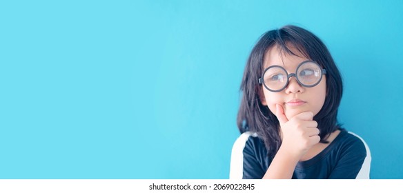 Healthy Eyes And Vision.Portrait Asian Nerd Kid Girl Child With Question Face Wearing Eyes Glasses.shot Eye Sign On Blue Background.Eye Care, Idea Think Optical Clinic.Education Smart Online Learning.