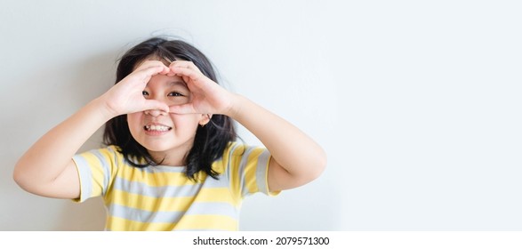 Healthy eyes and vision.Portrait happy asian kid child holding heart shaped hands on eyes.Smiling Girl With Healthy Skin Showing Love Sign. Eye care.Carotene vitamin.Focus, optician doctor, optical. - Shutterstock ID 2079571300