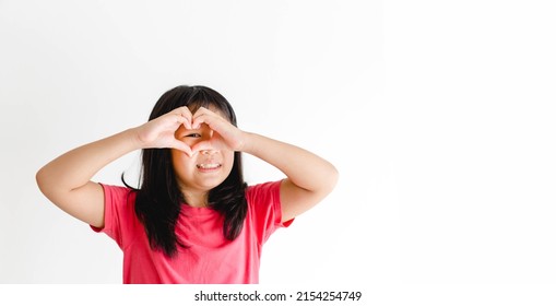 Healthy Eyes And Vision.Portrait Happy Asian Kid Child Holding Heart Shaped Hands On Eyes.Smile Girl With Healthy Skin Showing Love. Eye Care.medical Care Vitamin.Focus, Optician Doctor, Optical.tween