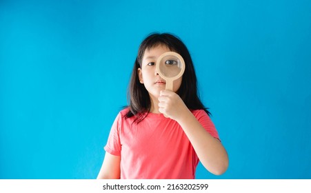 Healthy Eyes And Vision.Portrait Happy Asian Kid Child Holding Magnifying Glasses On Eyes.Smiling Girl With Healthy Skin Showing Love Sign. Eye Care.Carotene Vitamin.Focus, Optician Doctor, Optical.