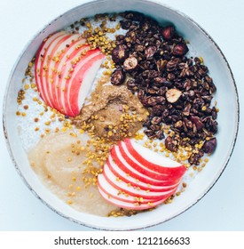 Healthy Fall Breakfast Bowl With Chia Pudding, Chocolate Granola, Apple, Apple Sauce, Almond Butter And Bee Pollen