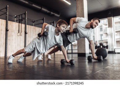 Healthy family concept. Father trainer and teenager son training with dumbbells in gym. Fitness, sports, active lifestyle - Powered by Shutterstock