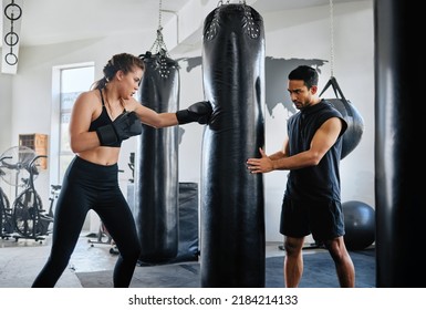 Healthy, Fit And Active Female Boxer Training, Exercising And Sparring With Her Coach, Trainer Or Instructor In The Gym Or Health Club. Young Woman Preparing For A Boxing Fight, Match Or Competition