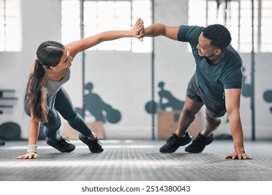 Healthy, fit and active gym partners exercising together as a couple, doing pushups and a high five. Boyfriend and girlfriend training and exercising in a health club as part of their workout routine - Powered by Shutterstock