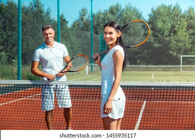 Healthy fit couple. Healthy fit couple wearing white clothes feeling satisfied after playing tennis together - Powered by Shutterstock