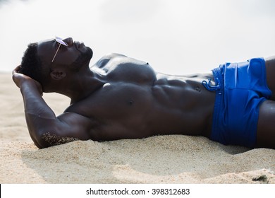Healthy, fit and muscular black african american man on a beach during sunset while on vacation