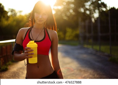 Healthy Fitness Girl With Protein Shake. Sport And Work Out Girl In Sunny Day 