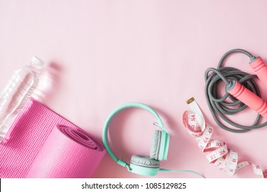 Healthy flat lay with sport and fitness equipments and mint color headphones on pink color background - Powered by Shutterstock