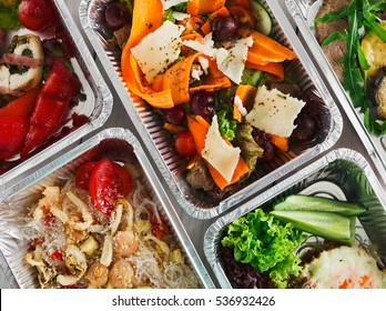 Healthy food background. Take away of natural organic food in foil boxes. Fitness nutrition, meat, rice vermicelli, vegetable salads and eggs. Top view, flat lay.