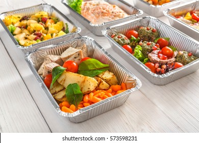 Healthy food background. Take away of natural organic meals in foil boxes. Fitness nutrition, meat, fresh salads, fruits and vegetables. Restaurant dishes delivery