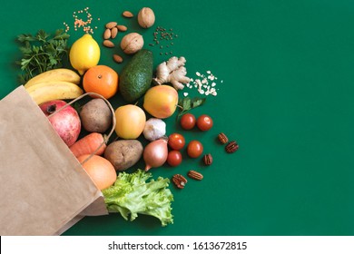 Healthy food background. Healthy vegan vegetarian food in paper bag vegetables and fruits on green, copy space. Shopping food supermarket and clean vegan eating concept. - Shutterstock ID 1613672815