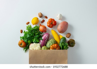 Healthy food background. Healthy vegan vegetarian food in paper bag vegetables and fruits on white, copy space. Shopping food supermarket and clean vegan eating concept