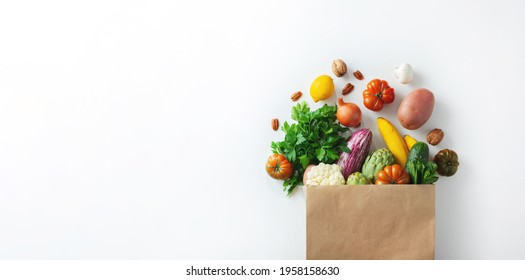 Healthy food background. Healthy vegan vegetarian food in paper bag vegetables and fruits on white, copy space. Shopping food supermarket and clean vegan eating concept - Shutterstock ID 1958158630