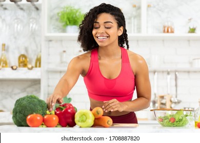 Healthy Food To Boost Your Immune System. Smiling Black Girl Cooking Salad At Home In Loft Kitchen Interor, Copy Space