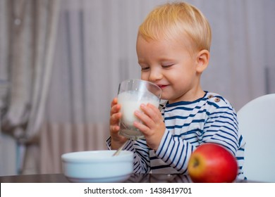Healthy Food. Boy Cute Baby Eating Breakfast. Baby Nutrition. Eat Healthy. Toddler Having Snack. Healthy Nutrition. Drink Milk. Child Hold Glass Of Milk. Kid Cute Boy Sit At Table With Plate And Food.