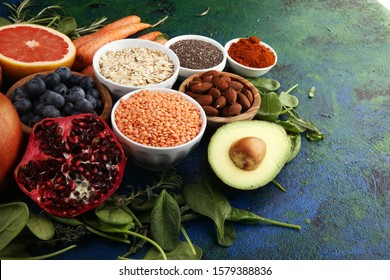 Healthy food clean eating selection: fruit, vegetable, seeds, superfood, cereals, leaf vegetable on background