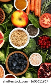 Healthy food clean eating selection: fruit, vegetable, seeds, superfood, cereals, leaf vegetable on background