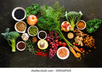Healthy food clean eating selection: fruit, vegetable, seeds, superfood, cereals, leaf vegetable on old kitchen table background copy space. Healthy food for humans