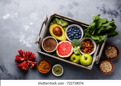 Healthy food clean eating selection in wooden box: fruit, vegetable, seeds, superfood, cereals, leaf vegetable on gray concrete background - Shutterstock ID 722718076
