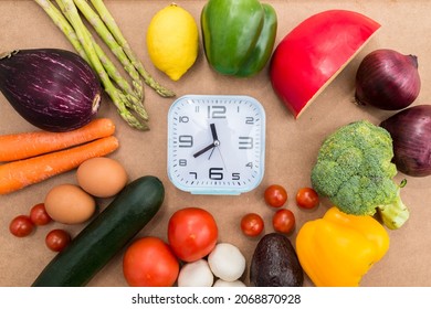 Healthy Food And A Clock On A Wooden Background. Conceptual Photograph About Intermittent Fasting, A Diet That Brings Benefits Such As The Regeneration Mechanism Of Autophagy.