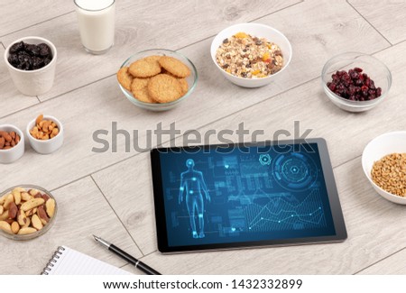 Healthy food composition with tablet. Body diagnosis on the screen