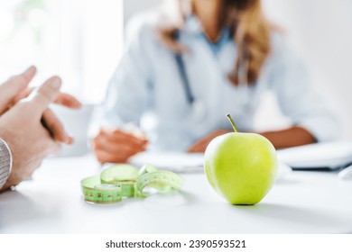 Healthy food concept. Cropped close up of woman doctor dietician recommending senior male patient fresh apple. Weight loss, diet for burning calories. Eating disorder issues