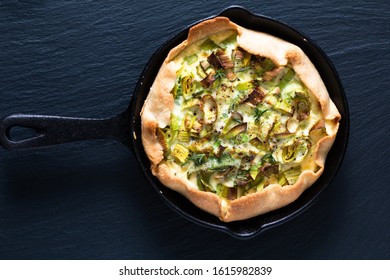 Healthy food concept homemade organic Leek quiche in skillet iron cast on black slate stone board - Powered by Shutterstock