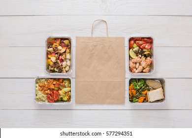 Healthy Food Delivery. Take Away Of Natural Fitness Dishes For Diet. Daily Meals In Foil Boxes On White Wood. Vegetables, Salmon, Meat And Salads. Top View, Flat Lay, Copy Space On Craft Package