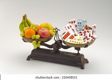 Healthy Food. Fresh Fruits And Vegetables Versus Medical Pills On A Scale. White Background.