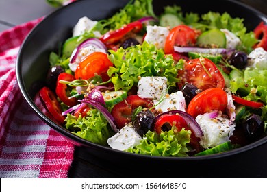  Gesundes Essen. Griechischer Salat mit Gurken, Tomate, Paprika, Salat, rote Zwiebel, Feta-Käse und Oliven.