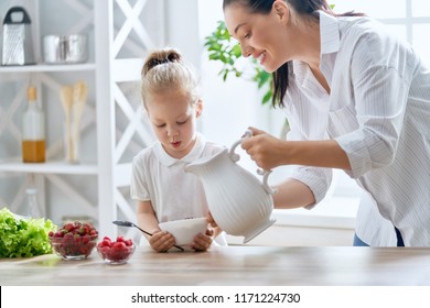 Healthy food at home. Happy family in the kitchen. Mother and child daughter are preparing breakfast.