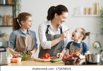 Healthy Food At Home. Happy Family In The Kitchen. Mother And Children Daughters Are Preparing Vegetables.