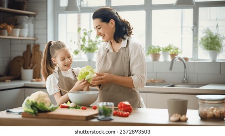 Healthy food at home. Happy family in the kitchen. Mother and child daughter are preparing proper meal. - Powered by Shutterstock