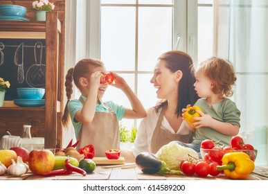 Healthy Food At Home. Happy Family In The Kitchen. Mother And Children Daughters Are Preparing The Vegetables And Fruit.