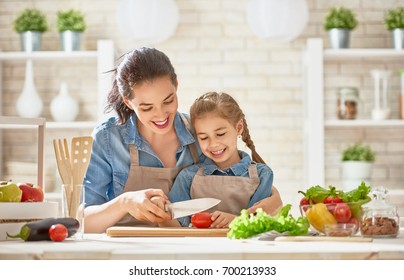 Healthy Food At Home. Happy Family In The Kitchen. Mother And Child Daughter Are Preparing The Vegetables And Fruit.