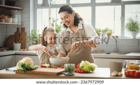 Healthy food at home. Happy family in the kitchen. Mother and child daughter are preparing proper meal.